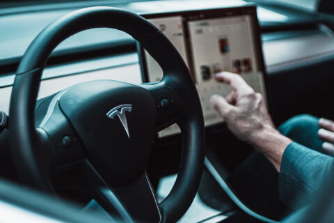 Person interacting with Tesla touch screen.